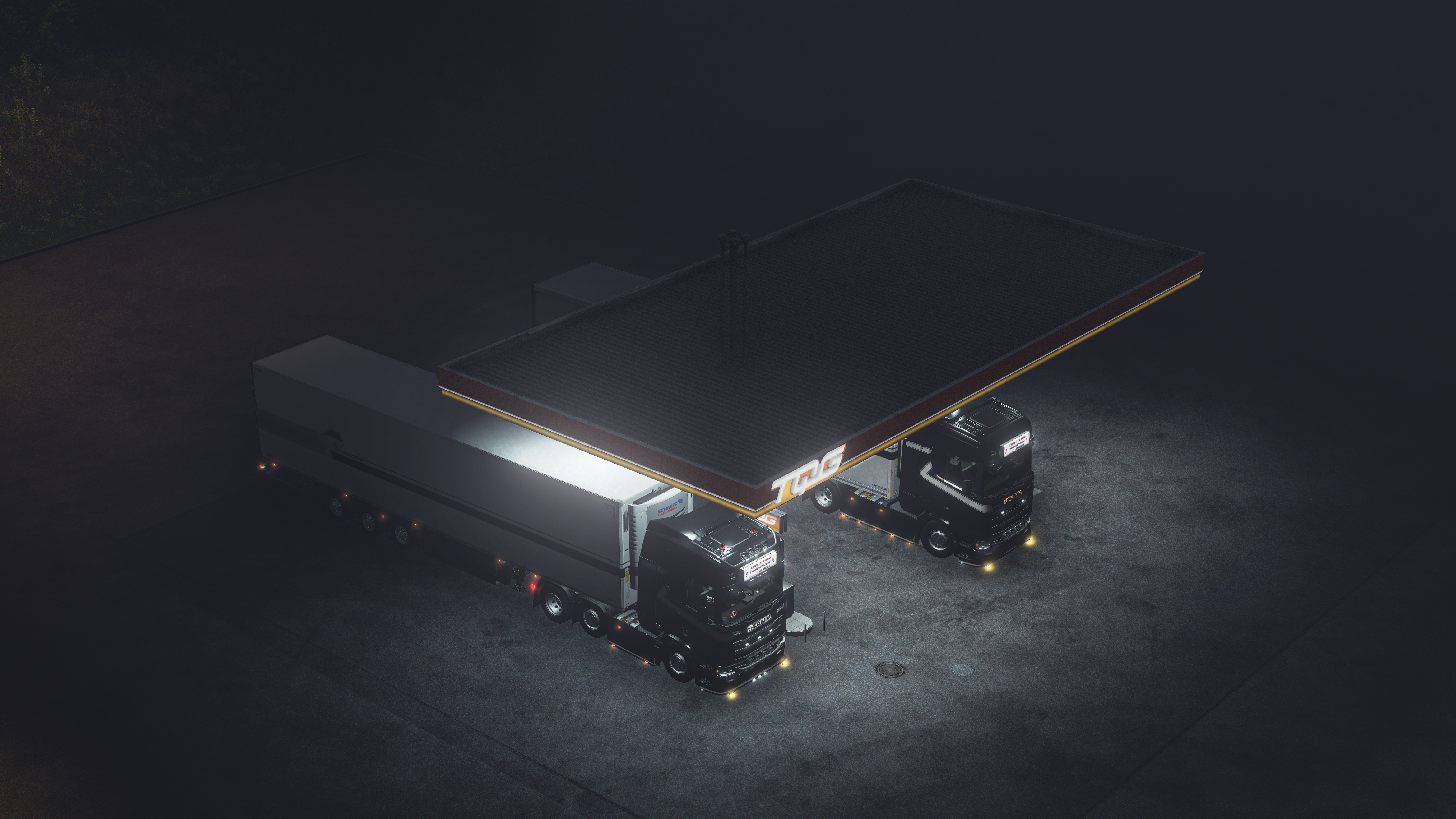 Two TнєrmoExprєss trucks parked under a canopy at night